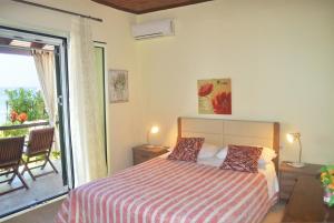 a bedroom with a bed and a balcony at Beachfront Vacation Home eftichia in Agios Gordios
