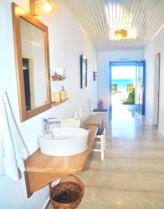W łazience znajduje się umywalka i lustro. w obiekcie Beachfront Vacation Home Eftichia w mieście Agios Gordios