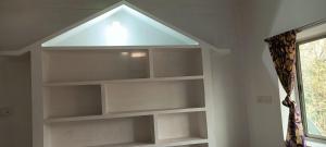 una estantería en una habitación con una luz encima en MONIKA MANSION Bodhgaya, en Bodh Gaya 62 fotos más