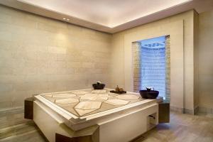 a large tub in a room with a window at Jumeirah Bali in Uluwatu