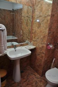a bathroom with a sink and a toilet and a shower at Hotel Lido in Mamaia