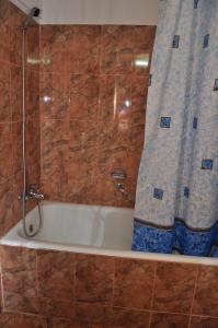 een badkamer met een douche en een bad met een douchegordijn bij Hotel Lido in Mamaia