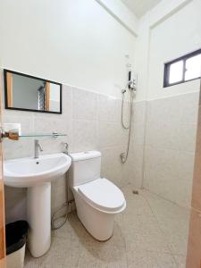 Łazienka z białą toaletą i umywalką w obiekcie Verra Inn w mieście Tagaytay