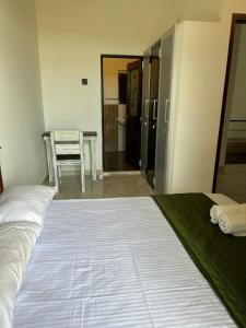1 dormitorio con cama, mesa y cocina en Tranquility By Natures Bliss en Ja-Ela