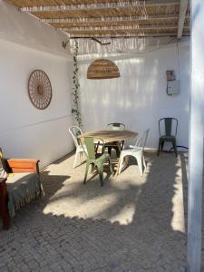 a patio with a table and chairs in a room at Casa Lavadeira - VINHAS de NEXE in Faro