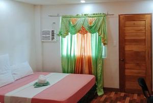 een slaapkamer met een bed met een regenboog gordijn bij RedDoorz @ 4ks Pension House Bogo City Cebu in Banban