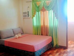 een bed in een kamer met een regenboog gordijn bij RedDoorz @ 4ks Pension House Bogo City Cebu in Banban