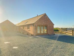 a brick house with a driveway in front of it at The Parlour - Uk41748 in Loppington