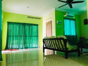 a living room with a bench and green walls at GREENS HOMESTAY in Sungai Besar