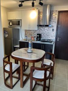 a kitchen with a table and chairs and a refrigerator at The Journeyman Suite at Covent Garden Sta Mesa Manila in Manila