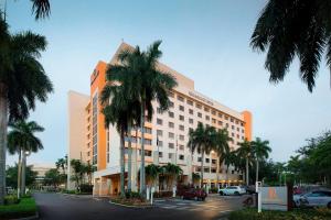 a large building with palm trees in front of it at Renaissance Fort Lauderdale West Hotel in Plantation