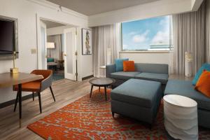 a living room with a couch and a table at Renaissance Fort Lauderdale West Hotel in Plantation