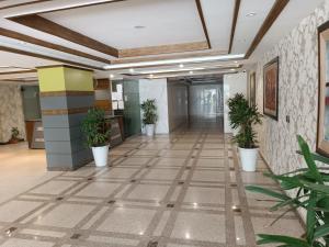 an empty hallway with potted plants in an office building at AQZ Three-bedroom apartment in Islamabad