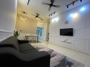 GS24 Muar في موار: غرفة معيشة مع أريكة وتلفزيون بشاشة مسطحة