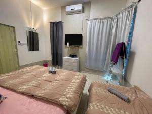 a room with two beds and a television in it at GS24 Muar in Muar