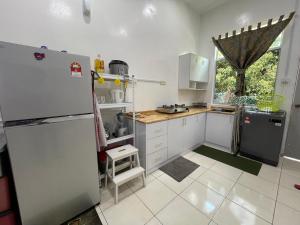 eine Küche mit weißen Schränken und einem Kühlschrank in der Unterkunft GS24 Muar in Muar