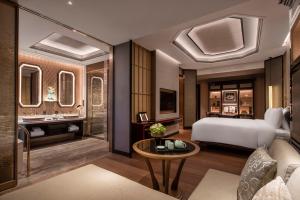 南京市にあるThe Ritz-Carlton, Nanjingのベッドとテーブルが備わるホテルルームです。