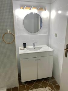 W białej łazience znajduje się umywalka i lustro. w obiekcie Casa Pedra Rosa - VINHAS de NEXE w Faro