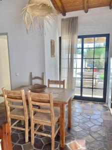 a dining room with a wooden table and chairs at Casa Pedra Rosa - VINHAS de NEXE in Faro