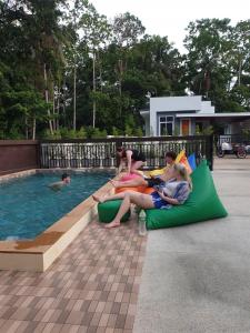 a group of people sitting on rafts by a swimming pool at BSK Bungalows in Lipa Noi