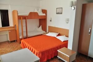 a bedroom with two bunk beds with an orange bed at Hotel Lido in Mamaia