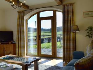 a living room with a sliding glass door with a view at Barn End Cottage in Millers Dale