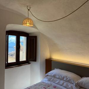 een slaapkamer met een bed en een raam bij La Taberna di Rocca Calascio in Calascio