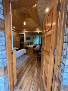 a bedroom with two beds and a wooden door at Hotel Neelgiri - Manali Diaries in Manāli