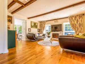 a living room with two couches and a fireplace at Kennel Cottage in Alwinton