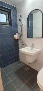 ein Bad mit einem Waschbecken und einem Spiegel in der Unterkunft High-Quality House Ocean view in Tongyeong