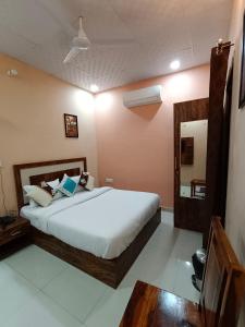 a bedroom with a large bed and a mirror at Hotel Greenoz in Jaipur