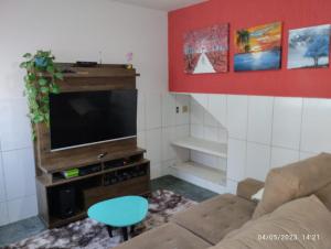 sala de estar con sofá y TV de pantalla plana en Andres Home casa H, en Governador Valadares