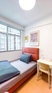 a bedroom with a bed and a desk and windows at Shared Apartment Lockhart Road 384 in Hong Kong