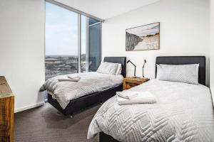 a bedroom with two beds and a large window at Penthouse 406 The Frontage Victor Harbor in Victor Harbor