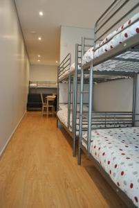 a room with four bunk beds with a table at Apartamentos Portodouro - Santa Catarina in Porto