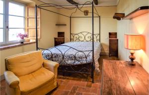 um quarto com uma cama e uma cadeira em Gorgeous Home In Cortona With House A Panoramic View em Cortona