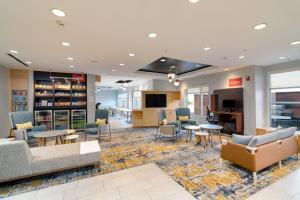 a library with couches and tables and chairs at TownePlace Suites by Marriott Dallas McKinney in McKinney