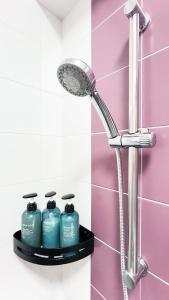een douche in een badkamer met 3 flessen water bij Shared Apartment Lockhart Road 384 in Hong Kong