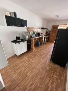 ein Wohnzimmer mit einer Küche und Massivholzböden in der Unterkunft Quarto com ótimo custo benefício in Parnaíba