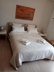 una camera da letto con un grande letto bianco con due asciugamani di A casa di Gio a Lecce
