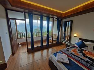 a bedroom with a bed and large windows at Hotel Norling SK Groups in Pelling