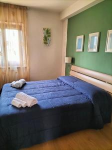 a bedroom with a blue bed with two towels on it at La Cerreta Affittacamere in Poggio