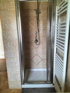 La salle de bains est pourvue d'une douche avec une porte en verre. dans l'établissement La Cerreta Affittacamere, à Poggio