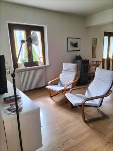 una sala de estar con 2 sillas y una lámpara. en La Cerreta Affittacamere, en Poggio