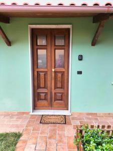 uma porta de madeira numa casa com um pátio de tijolos em La Cerreta Affittacamere em Poggio