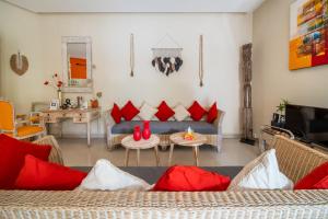 sala de estar con sofá azul y almohadas rojas en Villa Armani Seminyak, en Seminyak
