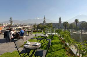 a patio with tables and chairs with a view of a city at Katari Hotel at Plaza de Armas in Arequipa