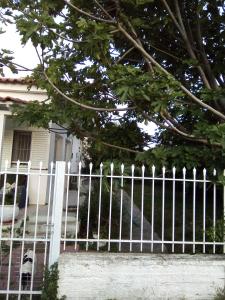 a white picket fence in front of a house at Marathon agios panteleimon attiki Greece in Panayía Mesosporítissa