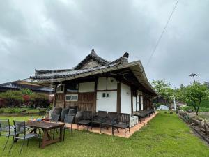 uma casa com cadeiras e uma mesa em frente em Big Blue House em Boseong