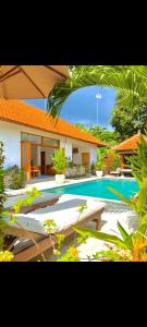 a swimming pool in front of a house at Villa Seruni Lovina in Lovina